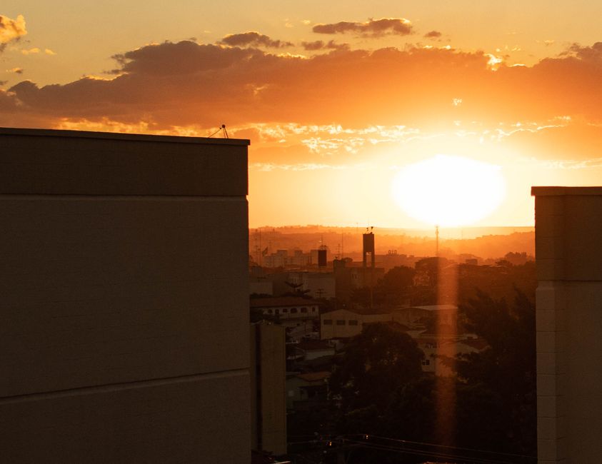 Le Soleil change-t-il vraiment de couleur au cours de la journée? Captivating sunset over city skyline with vibrant orange hues during golden hour.