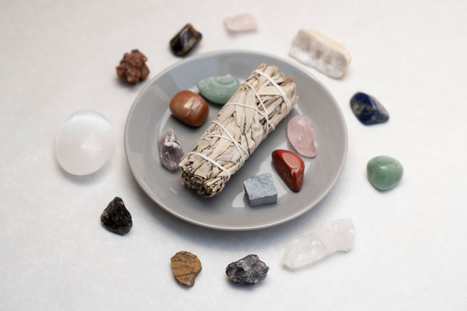 Les cristaux ont-ils vraiment des pouvoirs de guérison? Ceramic plate with sage smudge stick and healing crystals for spiritual rituals.