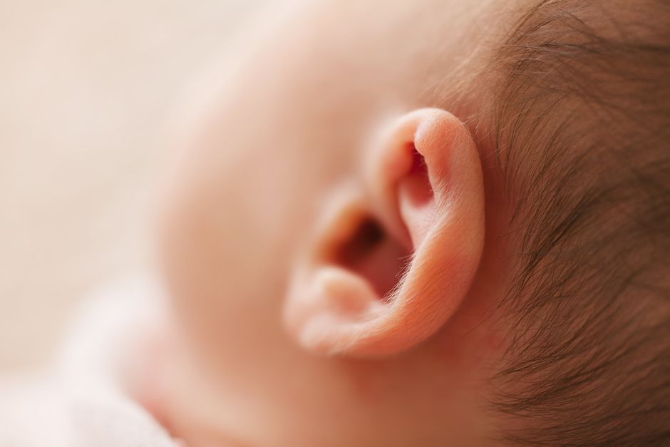 L’effet Mozart existe-t-il vraiment pour les bébés? Gentle close-up of a newborn baby's ear, showcasing delicate features in a soft focus image.